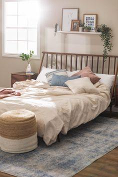 Obsessed with this neutral boho bedroom accented plants and a floating shelf with blue and pink accent colors.